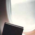 Passeport tenu près du hublot d’un avion