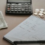 Calculatrice, billets et pièces posés sur un bureau