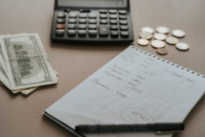 Calculatrice, billets et pièces posés sur un bureau
