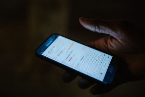 Main tenant un smartphone affichant une application de messagerie